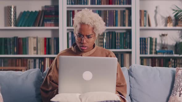 African Woman Using Laptop at Home Feeling Anxious of Bad Electronic Device Work