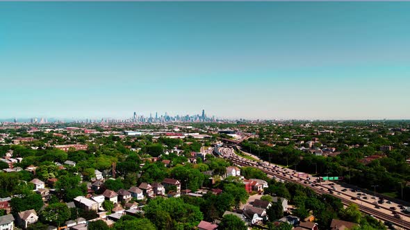 4k slow flight towards interstate above chicago suburbs while having chicago always on view, many tr
