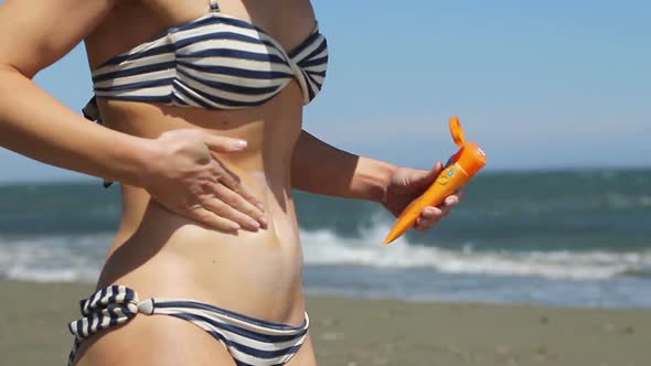 Hot Woman With Beautiful Body Applying Sun Cream to Protect Skin From Sunburns