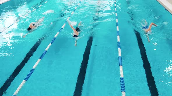 Three Athletes Swimming in a Pool