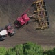 Aerial View of the Tractor Works in the Field Sows and Plows the Soil at the Same Time - VideoHive Item for Sale