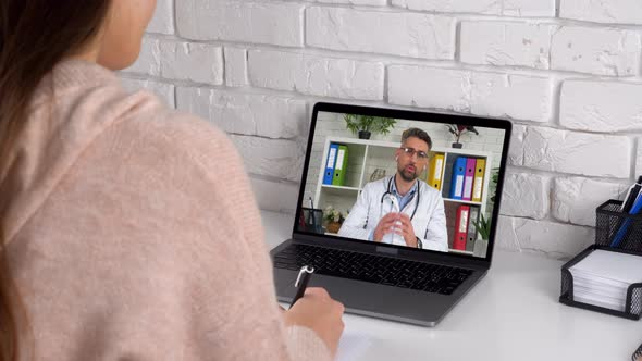 Doctor in laptop screen consults online conference video call computer webcam