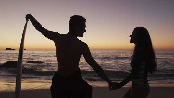 Young adult couple relaxing on a beach at sunset