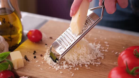 Making Pasta Carbonara  Grating Parmesan Cheese on Wooden Cutting Board
