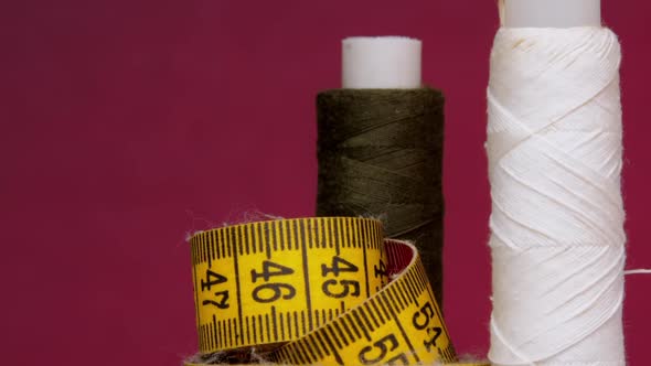 Brown and White Threads on Spools Near Yellow Measuring Tape