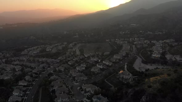 Aerial Slide Reveal of Sun Setting Behind Mountain