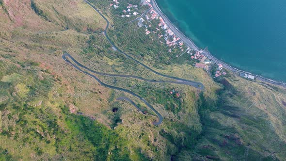 Scenic and winding coastal road leading down to Paul do Mar, Madeira; drone