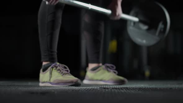 Anonymous Female Performs a Deadlift with Barbell Lifts Barbell and Does Weights Training in the Gym