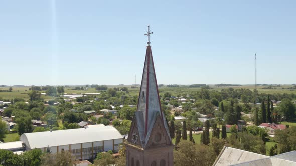 Orbital close up of a romantic style church tower and cross with Santa Anita town and Entre Rios cou