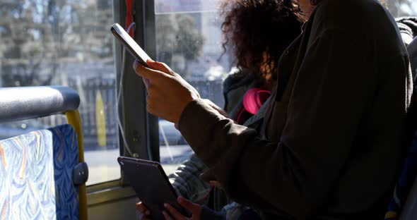 Mother and daughter using digital tablet while travelling in bus 4k