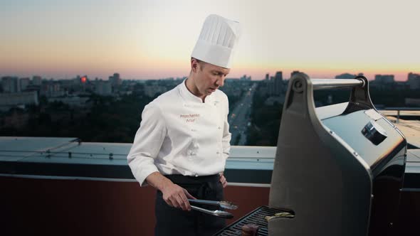 A professional Chef prepares a barbecue on the rooftop of a skyscraper. An expensive restaurant