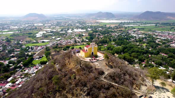 Orbital drone shot of church on top of hill in Atlixco Mexico