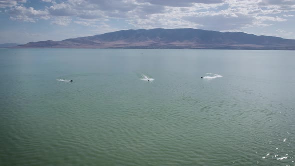 Three Jet Ski Riders on Sea Doos Speeding on Utah Lake Water Surface