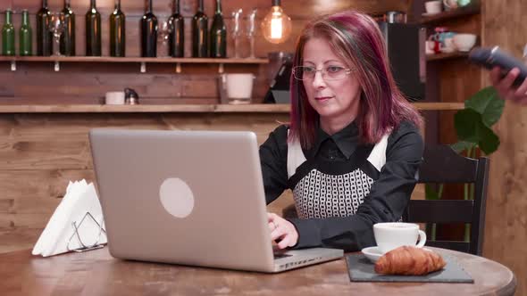 Adult Woman Pays with NFC Payments in a Vintage Coffee Shop