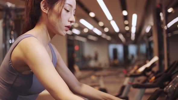 Young beautiful asian woman running on a treadmill at gym. Fitness and healthy lifestyle