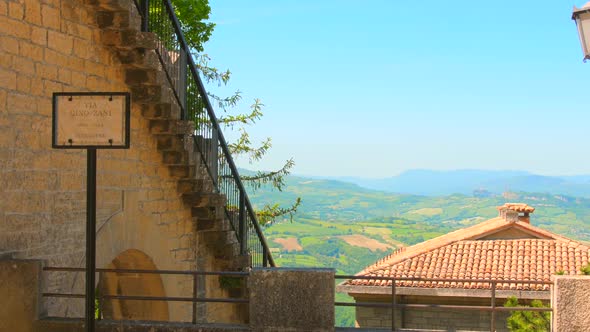 Pan shot over beautiful hilly terrain surrounded by historic architecture in San Marino, northern It