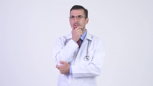 Young Happy Hispanic Man Doctor Smiling and Thinking