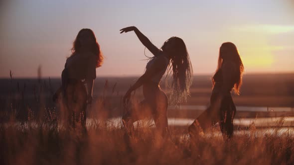 Three Young Women Doing Aerobic Movements on Sunset