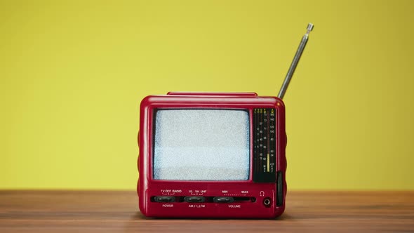 Small Old Television with Grey Interference Screen on Yellow Background