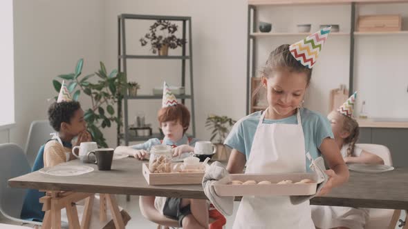 Girl Holding Baking Sheet with Cookies