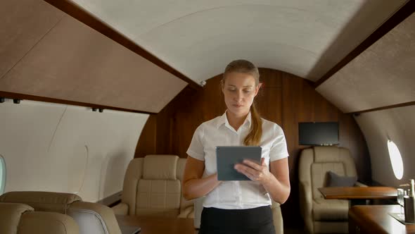 Business Woman in Air Private Jet Surfing Internet on tabletPC