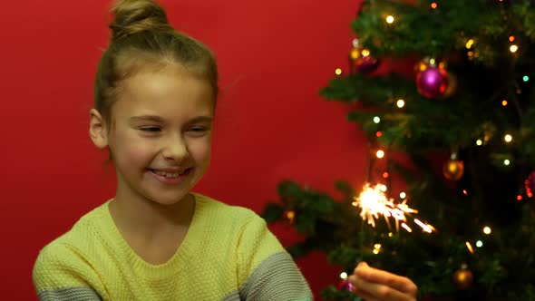 The Girl Holds a Sparkler And Tries to Smile Fearing Crackles and Flashes of Fire 