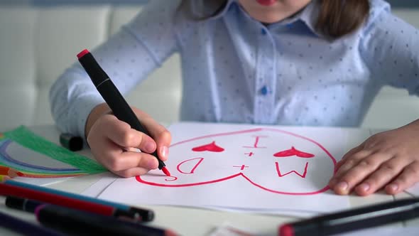 Child Draws Hearts on Paper with Pink Markers