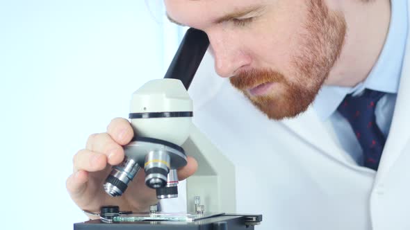 Doing Scientific Researcher using Microscope in Laboratory