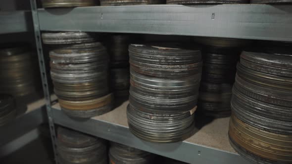 Archive of shelves with оld round metal boxes with film strip in them.