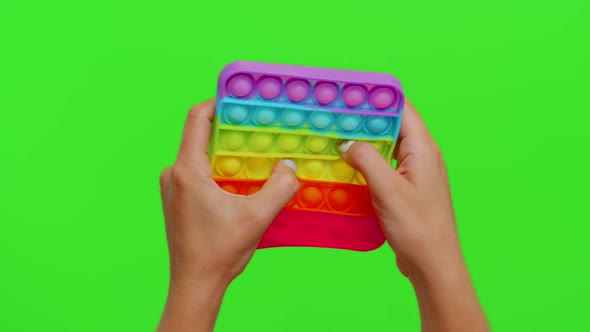 Female Hands with Push Pop It Bubble Fidget Stress Anxiety Relief Squeeze Sensory Toy on Chroma Key