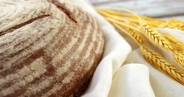 Sourdough with wheat grains on wooden table