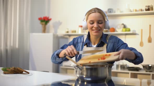 Positive Girl Listening Music and Cooking Vegetables, Healthy Low-Calorie Eating