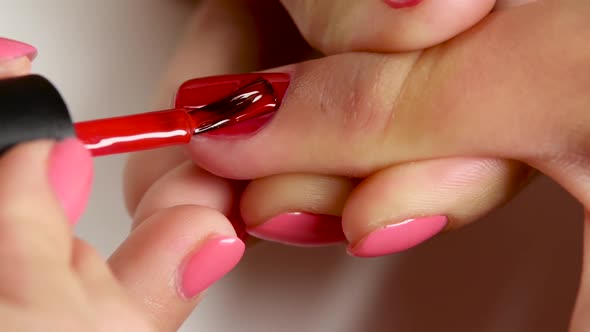 Manicurist Is Stain the Nail of Client By Red Varnish. Close Up