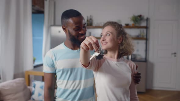 Happy Multiethnic Couple Smiling at Camera and Showing Keys From New Apartment