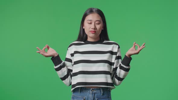 Asian Woman Concentrate In Front Of Green Screen Background