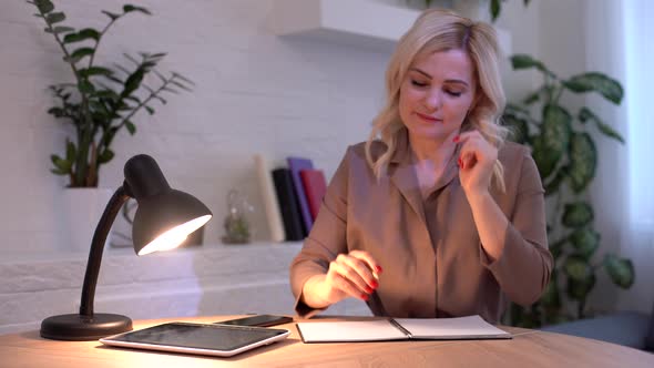 Positive Caucasian Woman Taking Pen and Writing Down Business Plan