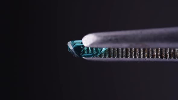 Natural Blue Grandidierite Gemstone in the Tweezer on the Turn Table