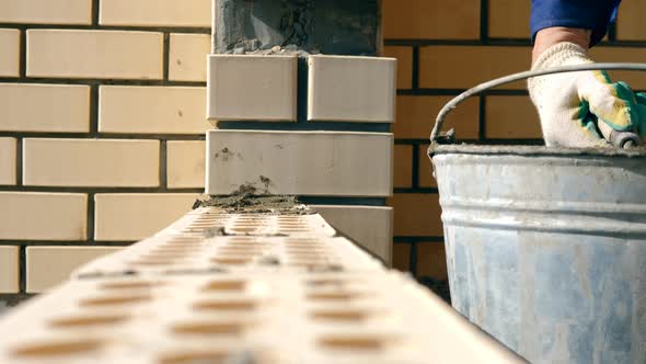 Side View of Concrete Getting Spread on the Bricks