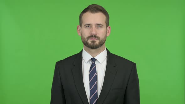 Young Businessman Looking in Camera Against Chroma Key