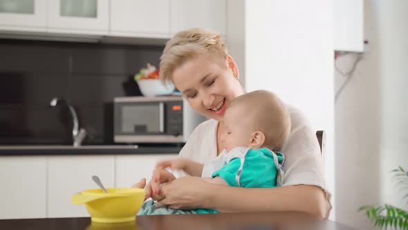 Happy Woman Entertaining Her Son While Feeding