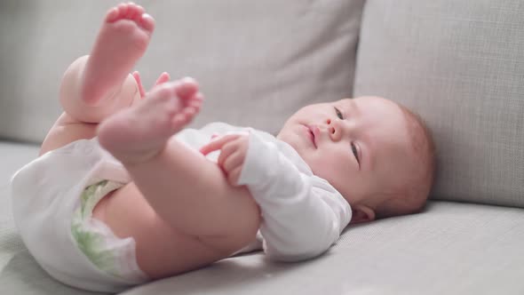 Mom Changes Diapers for Little Daughter in the Morning in the Sun