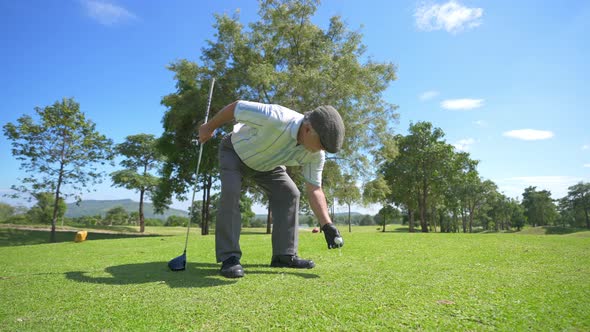 4K Asian senior man golfing at golf course on summer vacation