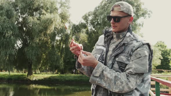 Confident Fisherman Preparing a Rod for Fishing at the Pond