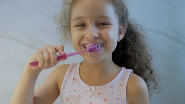 Portrait Happy Cute Young Teenage Girl Brushing Teeth in Bathroom and Smiling. Children Daily