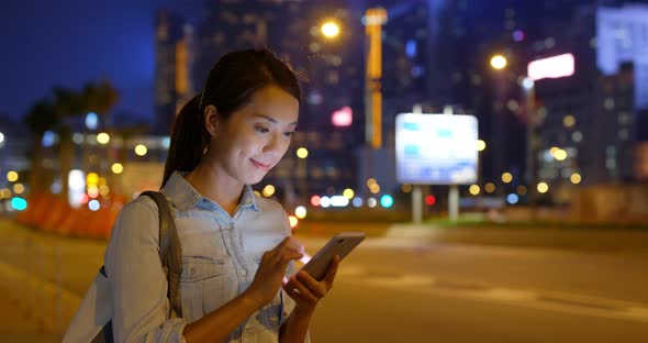 Woman use of mobile phone at night in city