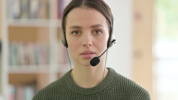 Call Center Young Woman with Headset Looking at the Camera