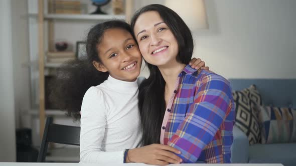 Portrait of African American Young Girl Talking and Laughing with Her Adult School Teacher Looking