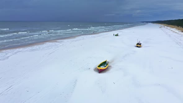 Fishing boats on snowy beach. Winter Baltic sea. Aerial view