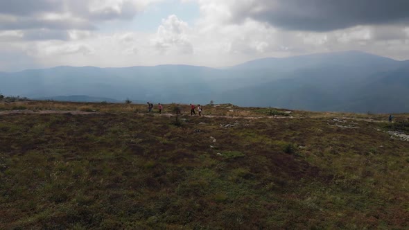 Aerial view of traveling family hiking by epic mountains