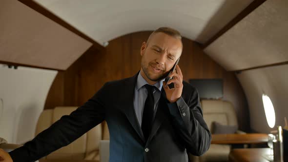 Private Jet Business Journey Concept. Businessman Talking on Mobile Phone.